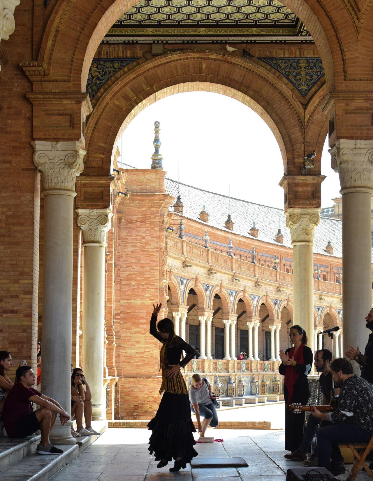 a group of people sitting and standing around a building